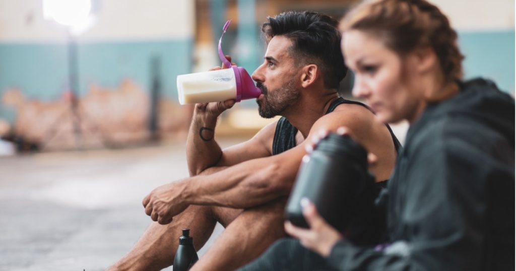 运动男男女女坐着喝蛋白奶昔