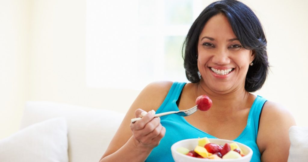 女人吃一碗水果。