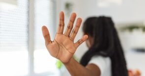 一个女人伸出手掌，暗示她在对别人问她的事情说“没门”。